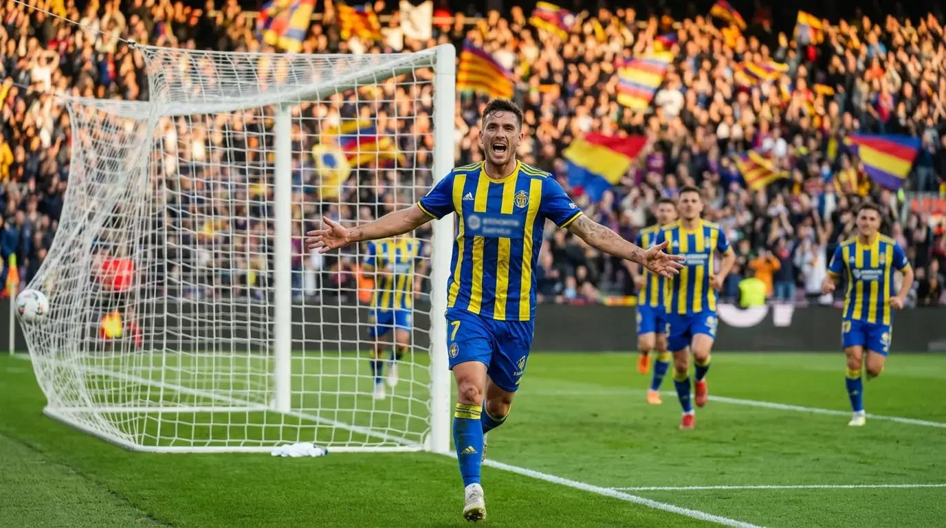 Football striker celebrating a goal with arms raised in front of the net on a stadium pitch